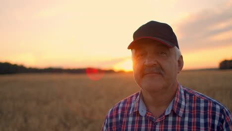 Close-up-portrait-of-a-farmer-in-a-cap-at-sunset-looking-directly-into-the-camera